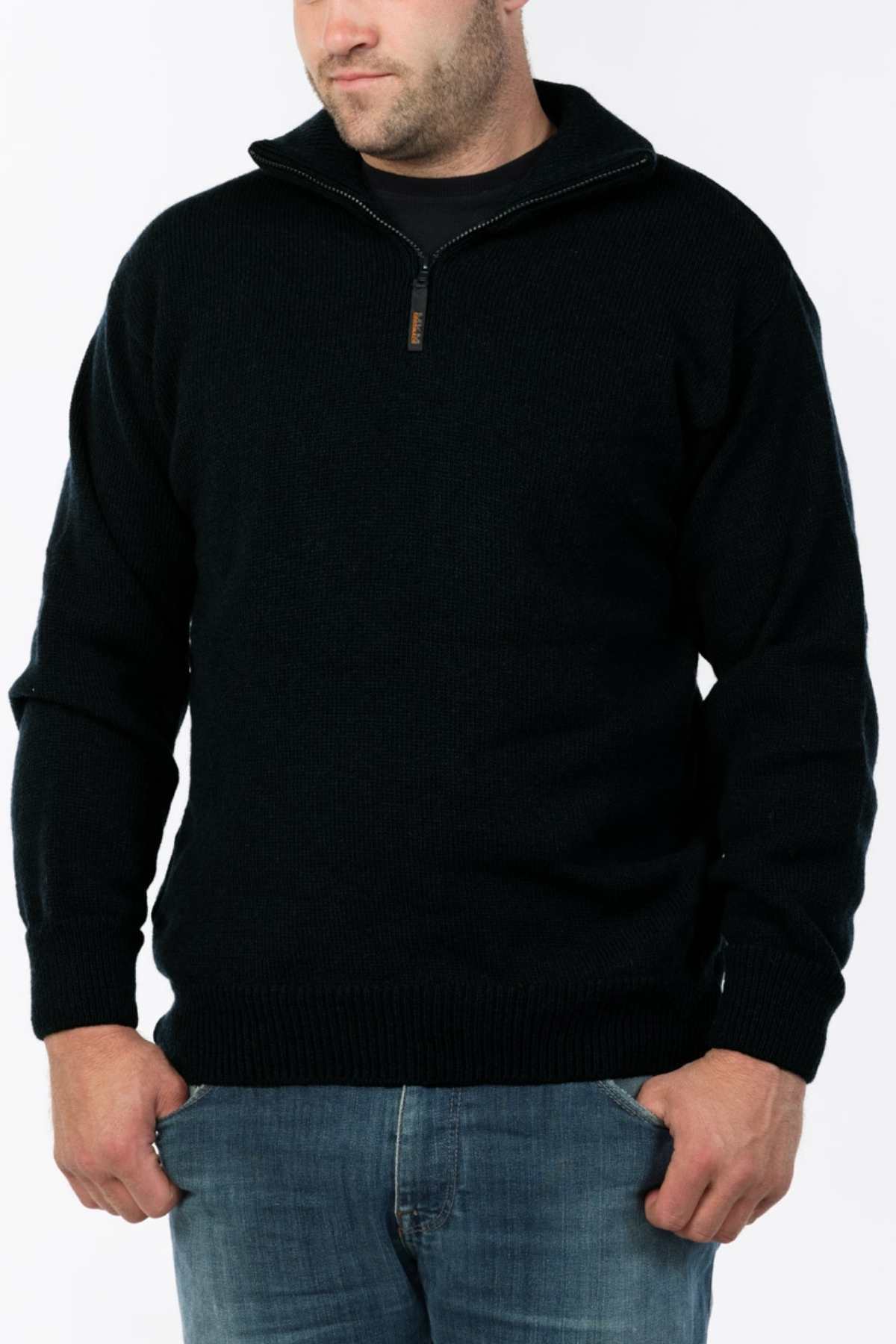 A man wearing the MKM Windbreaker Knit, a 100% wool jumper with a quarter-zip collar, stands against a plain light background. His hands are tucked into his jeans pockets, highlighting the premium craftsmanship made in New Zealand.
