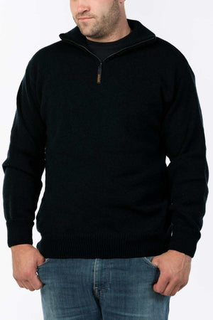 A man wearing the MKM Windbreaker Knit, a 100% wool jumper with a quarter-zip collar, stands against a plain light background. His hands are tucked into his jeans pockets, highlighting the premium craftsmanship made in New Zealand.
