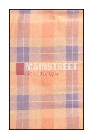 A pastel plaid fabric with orange, cream, and lavender stripes is adorned with "MAINSTREET clothing destination" in white and brown, crafted from high quality cotton inspired by Milton Ladies Flannelette Shirts.