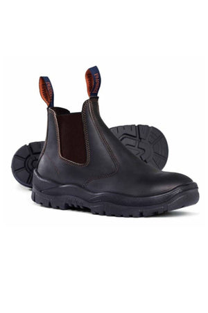 The Mongrel Safety Elastic Sided Boot 240030 is a pair of dark brown leather Chelsea boots with rugged, slip-resistant black soles, elastic side panels, and front and back pull tabs. One stands upright while the other lies on its side to display the tread.