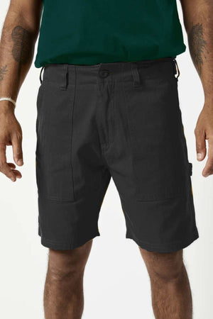 Someone wearing Mr Simple Carpenter Walk Shorts in a relaxed fit, paired with a dark green shirt. The herringbone cotton fabric adds texture, and their tattooed arms stand out against the plain white background.