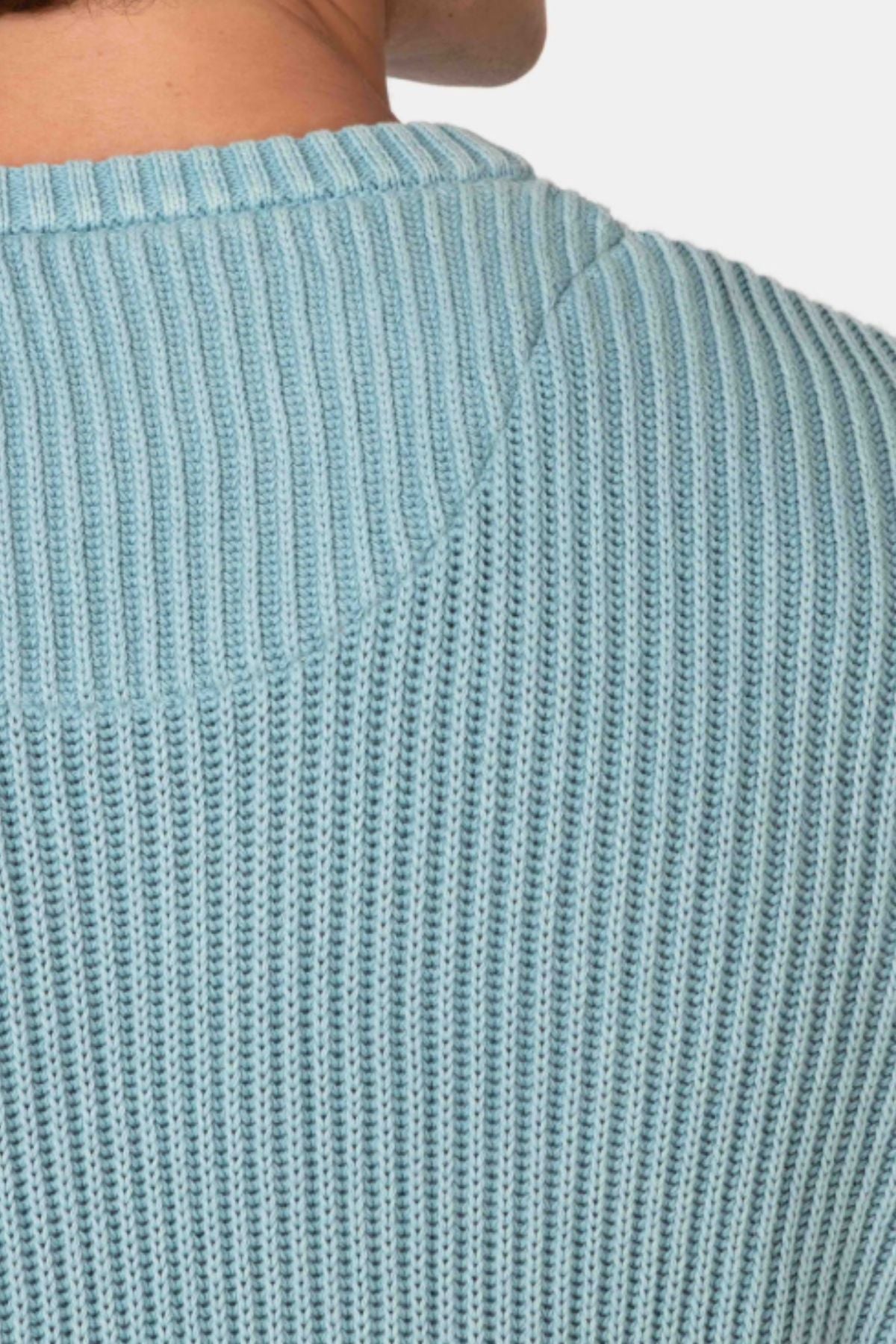 Close-up of a person wearing the Mr Simple Fisher Knit in light blue, showcasing its textured fabric, collar detail, and relaxed fit.