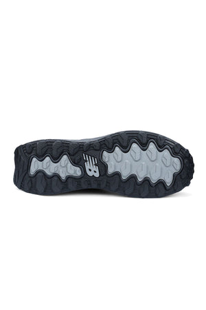 The image shows the black and gray rubber outsole of the New Balance Cremorne Safety Shoe, featuring a wavy, slip-resistant tread pattern and a white New Balance logo at the center.