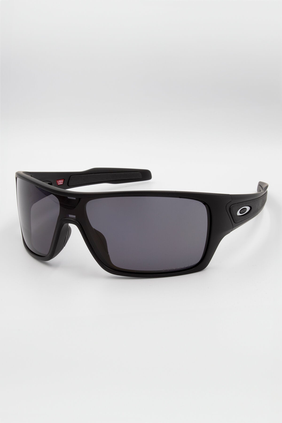 A pair of Oakley Turbine Rotor Sunglasses in black, featuring rectangular UV protection lenses and a stress-resistant wraparound frame, displayed on a light gray background. The iconic Oakley "O" logo is prominently showcased on the temples.