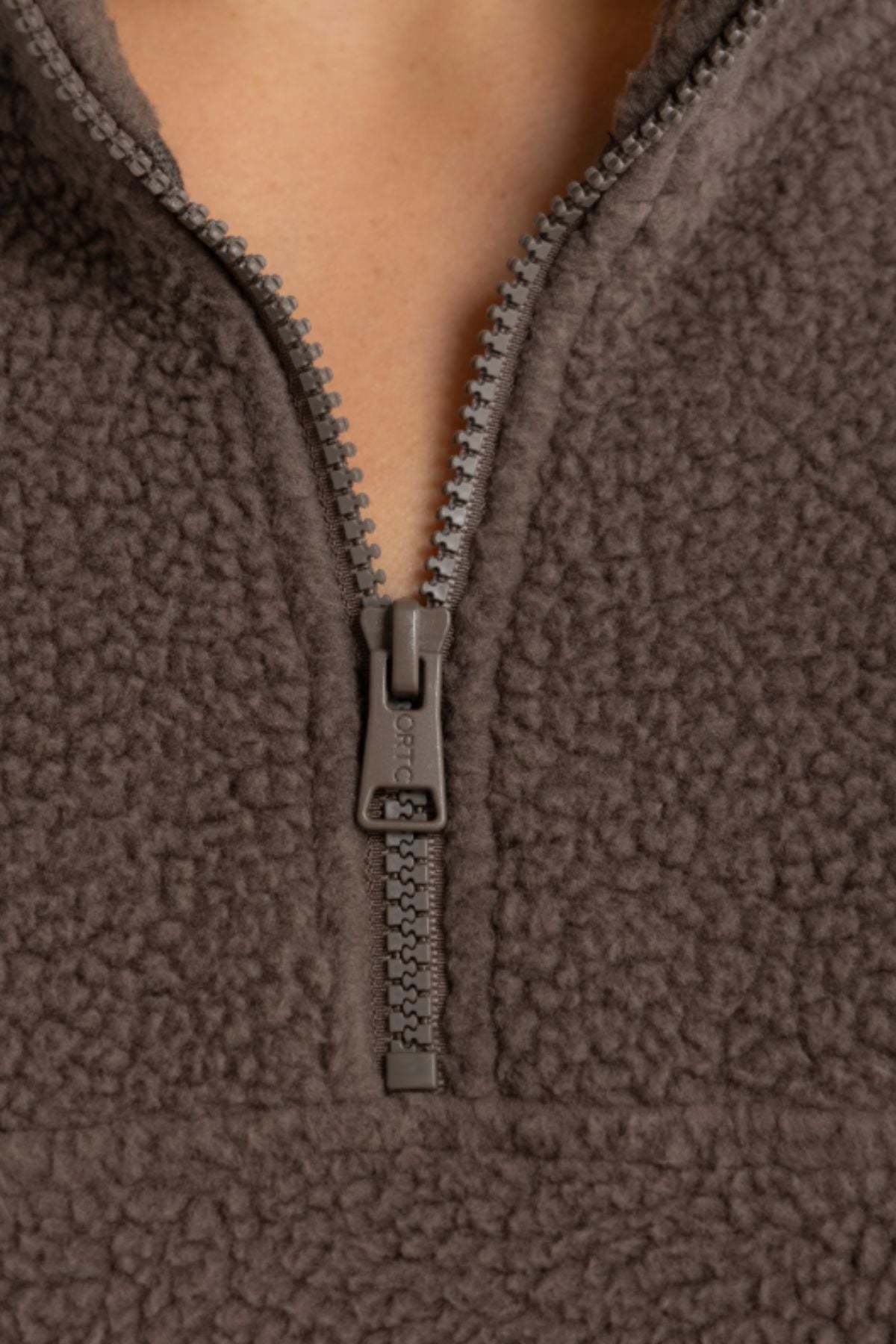 Close-up of the ORTC Sherpa Fleece Quarter Zip, featuring a soft, fuzzy brown fabric and a central quarter zip—ideal for warmth and comfort on chilly days.