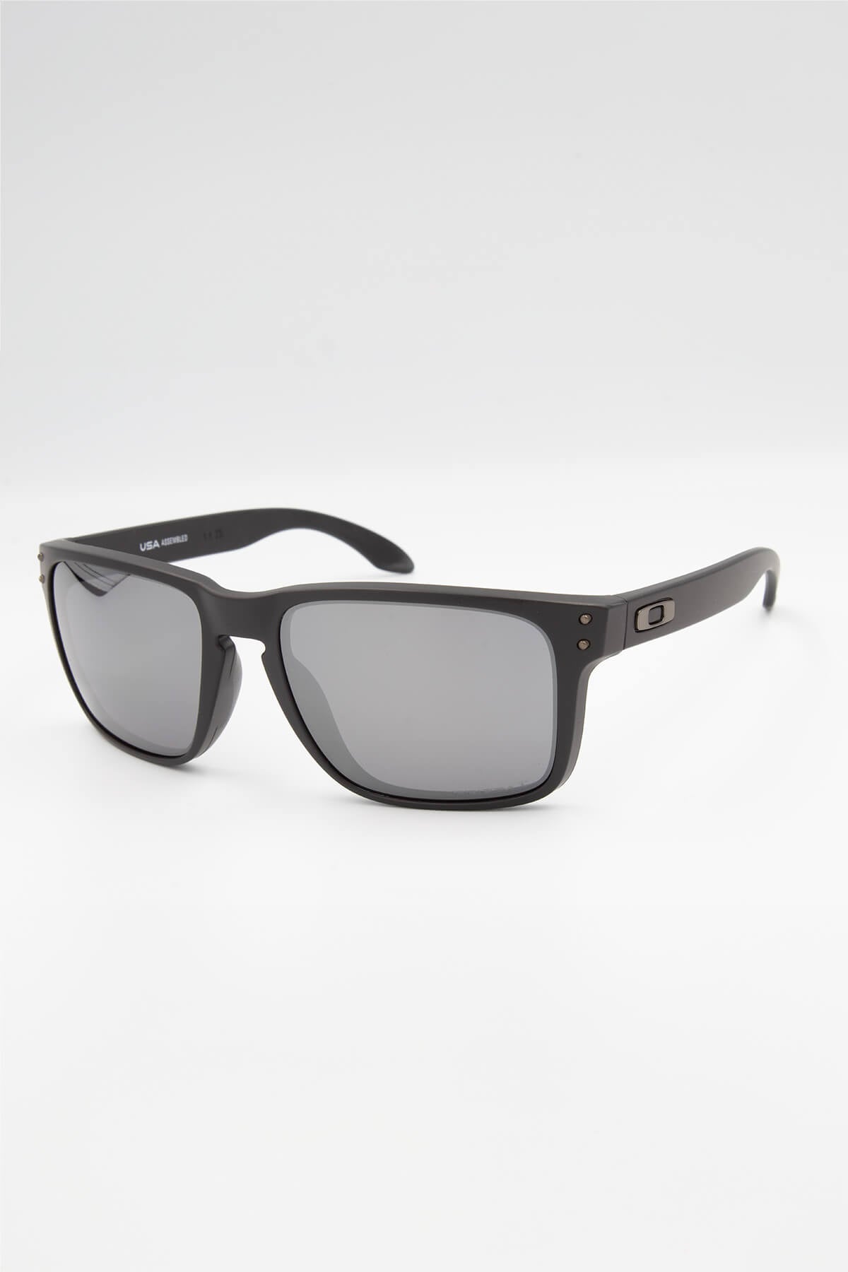 A pair of Oakley Holbrook XL Polarized sunglasses with a black rectangular matte frame, small metallic side logo, and dark HDPolarized lenses is displayed on a white background.