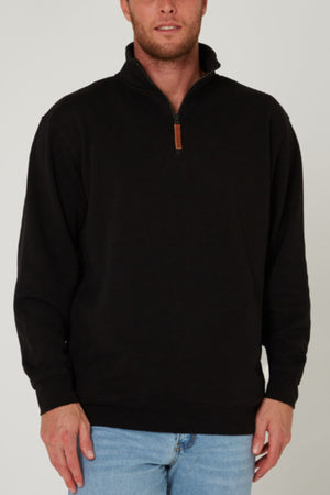 A man wearing a black Pilbara Classic Fleece Pullover with cozy fleece lining and light blue jeans stands against a plain light background. His face is partially out of frame.