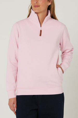 Wearing the Pilbara Ladies Classic Fleece Pullover in light pink, featuring a quarter-zip and stand-up collar, a person stands with one hand in their pocket against a plain background, paired with dark pants.