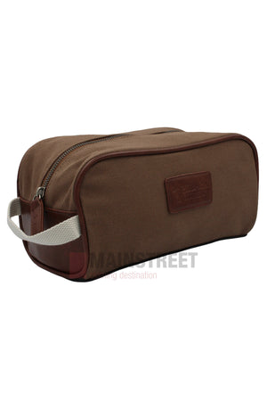 The Pilbara Toiletry Bag is a brown rectangular canvas bag with a white fabric handle, brown leather accents, and a top zipper. Ideal for luxury travel, it’s showcased on a white background.