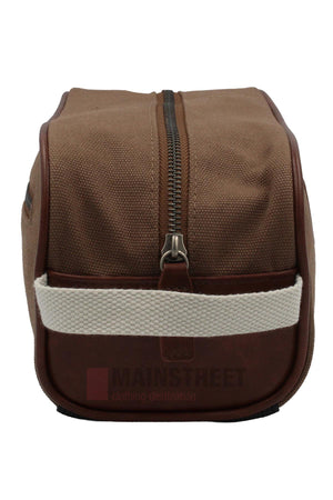 The Pilbara Toiletry Bag features premium canvas, a top zipper, brown leather trim, and a white fabric handle, displayed from the front against a plain background.
