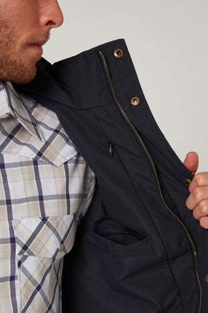 A man holding the Pilbara Two Tone Vest, a waterproof vest with polyfill padding.