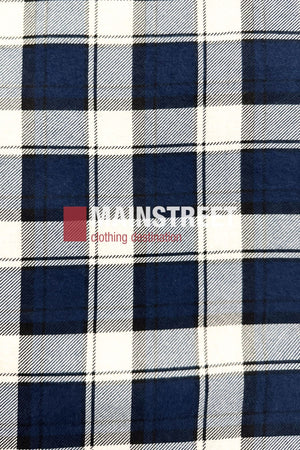 The Pilgrim Closed Front Flannelette Shirt - King Size features a blue, black, and white plaid pattern with long sleeves and a "MAINSTREET Clothing Collection" logo in white and red across the center for classic Pilgrim-inspired style.