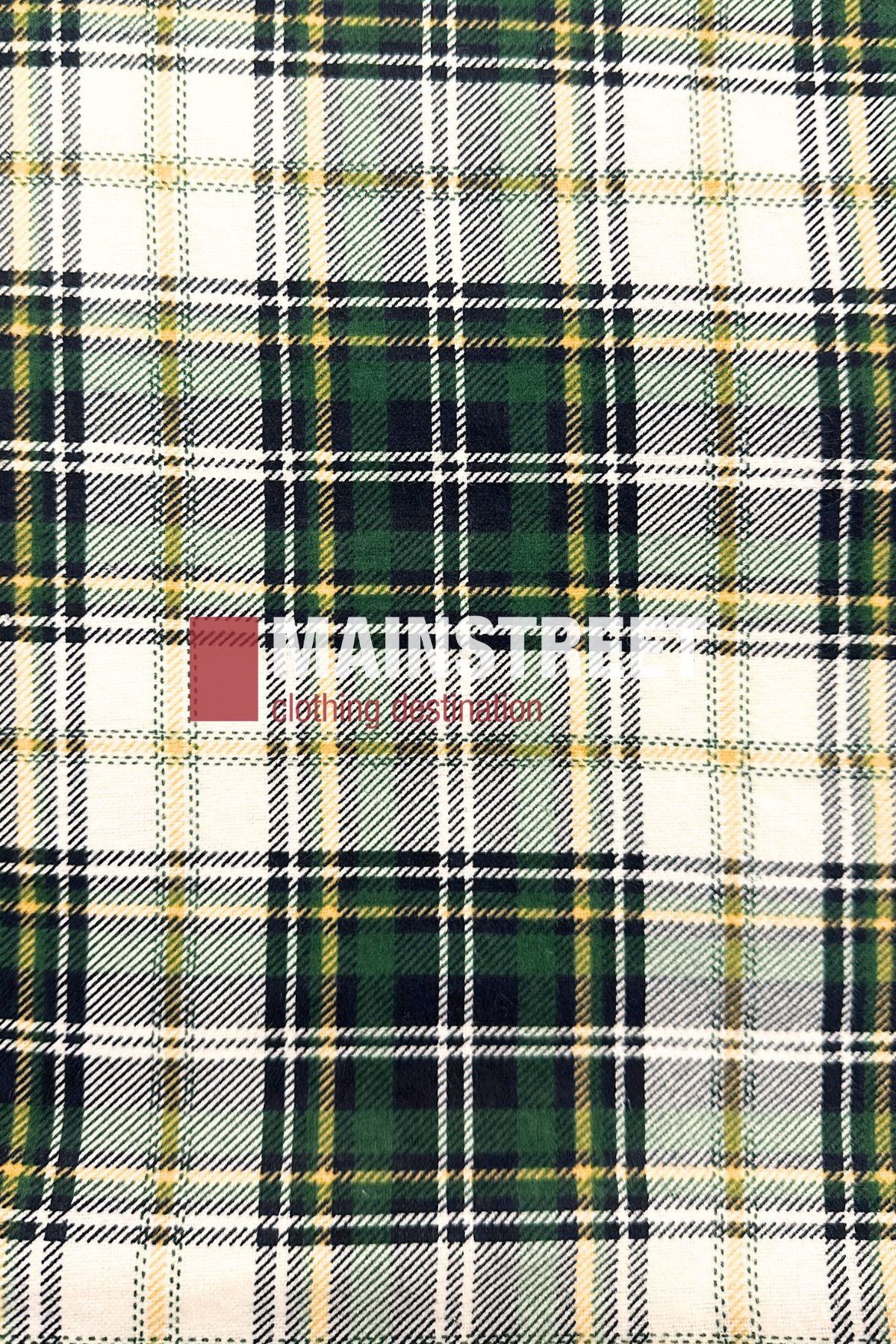 The Pilgrim Closed Front Flannelette Shirt - King Size features a green, yellow, black, and white plaid pattern with "MAINSTREAM clothing distribution" faintly centered. Made from 100% cotton for comfort and style.
