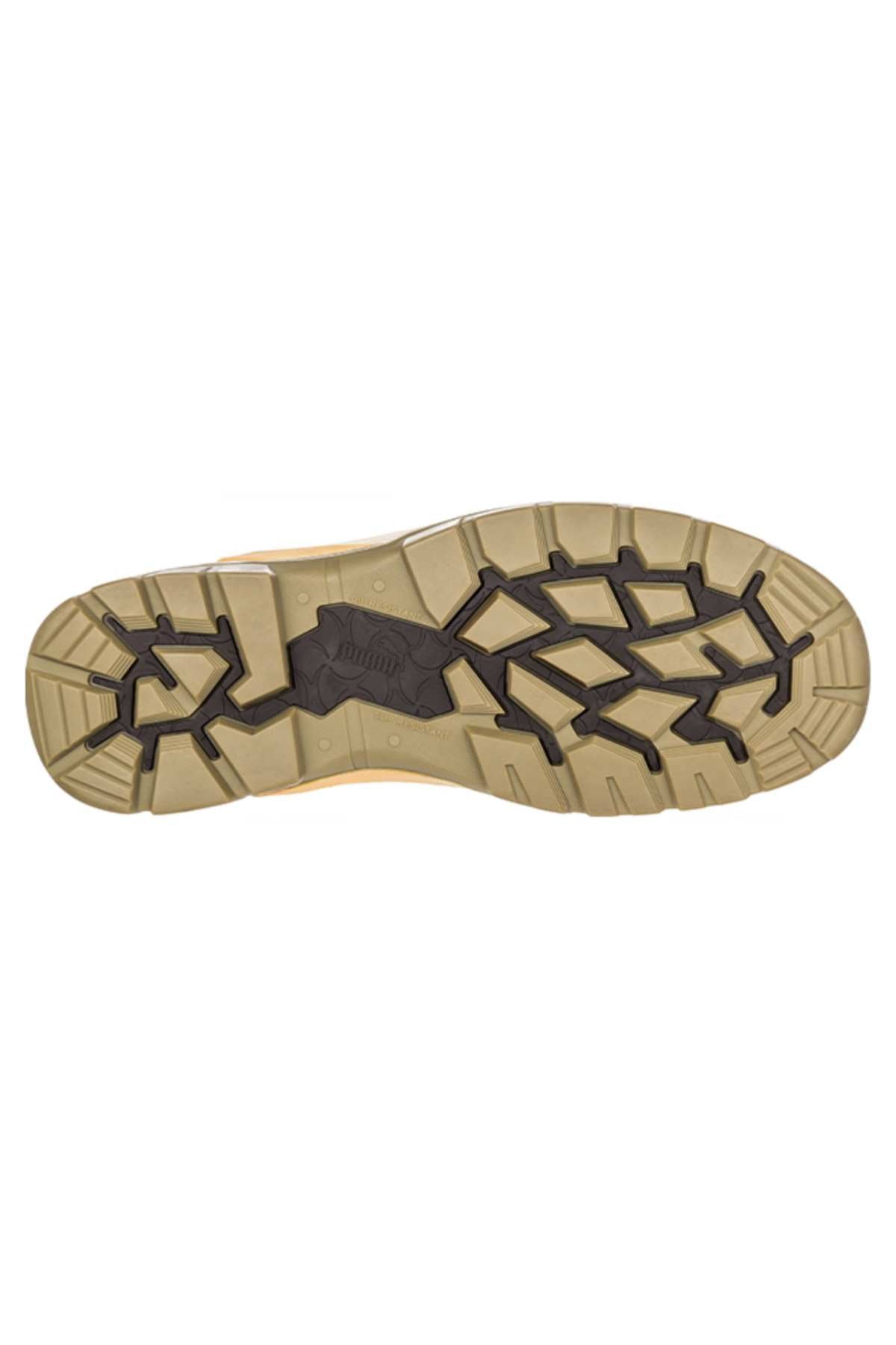 The image displays the bottom of a Puma Tanami Scuff Cap Elastic Sided Safety Boot in beige, featuring a rugged black tread with deep grooves, angular shapes for durability and grip, and a heat-resistant rubber sole designed for traction.
