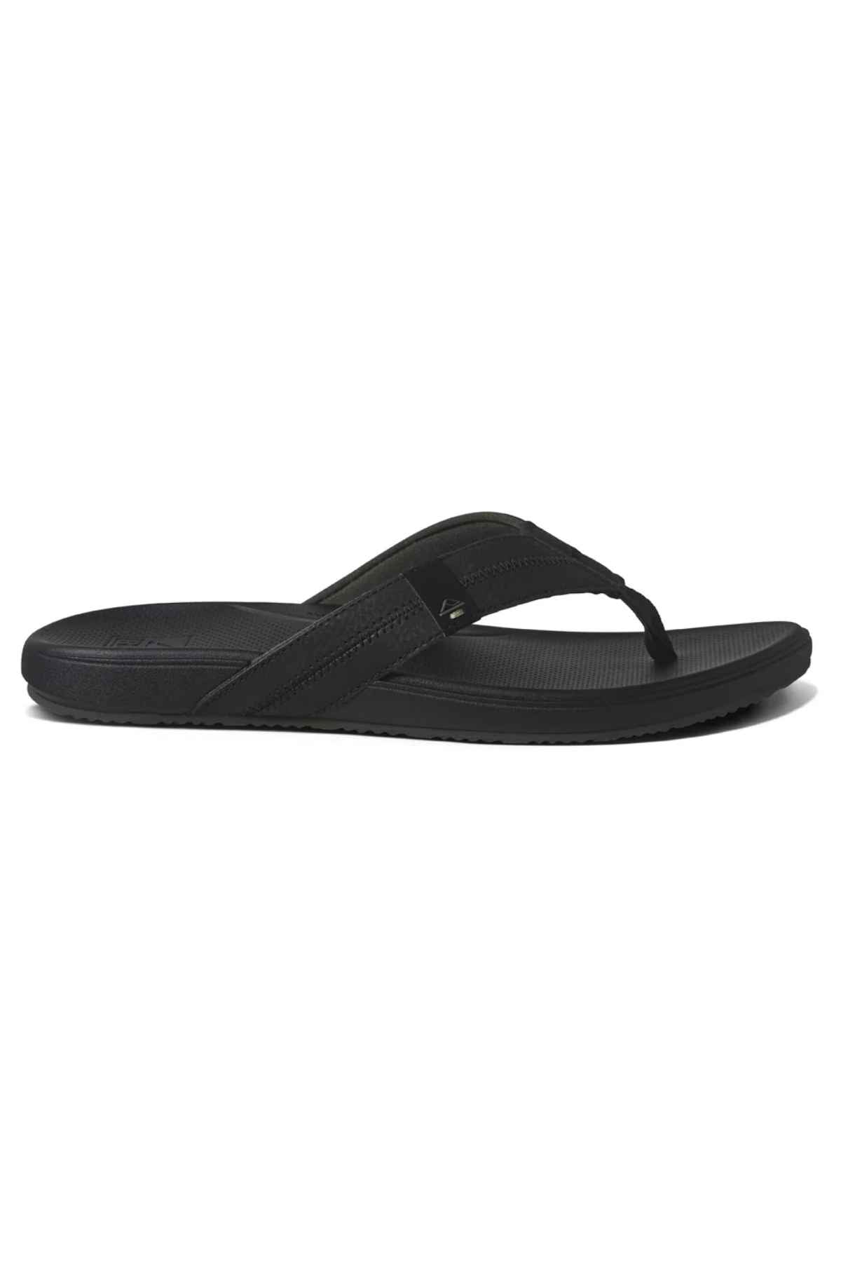 The REEF Cushion Phantom 2.0 is a black flip-flop sandal featuring a textured footbed, thick fabric strap, minimalist design, and built-in arch support for all-day comfort—displayed in a side profile view.