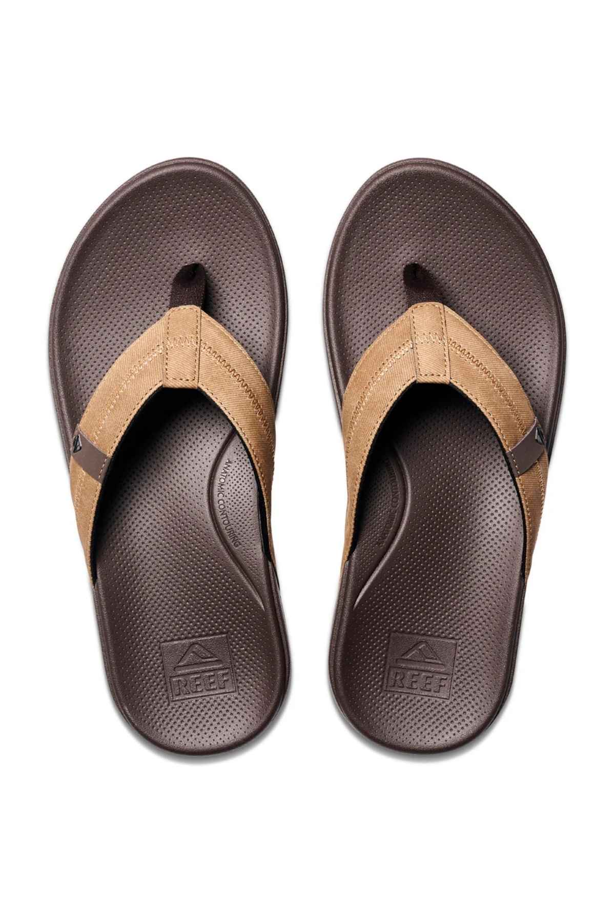 A pair of REEF Cushion Phantom 2.0 brown flip-flop sandals with textured soles, molded rubber outsole, and tan straps, shown from above on a white background.