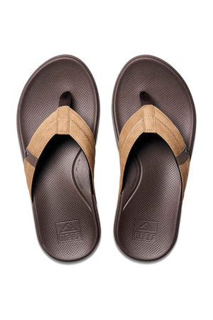 A pair of REEF Cushion Phantom 2.0 brown flip-flop sandals with textured soles, molded rubber outsole, and tan straps, shown from above on a white background.