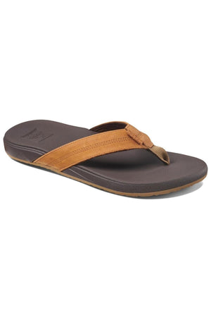 The REEF Cushion Phantom LE is a brown thong sandal with a dark brown sole and tan full grain leather strap, featuring a cushion footbed, shown on a white background.