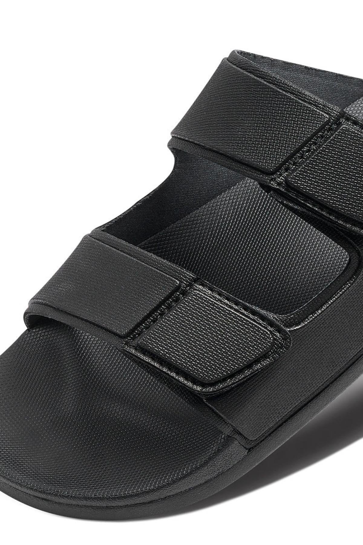 The REEF Cushion Tradewind is a black medical walking sandal with two wide adjustable Velcro straps and a cushioned footbed, designed to support and protect your foot after surgery or injury.