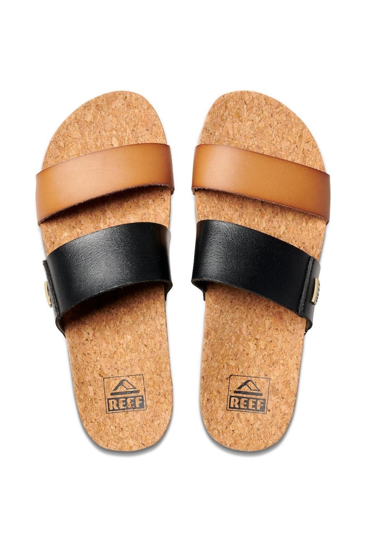 The REEF Cushion Vista Duo sandals offer cork footbeds and cushion bounce for comfort, featuring a brown top strap and a black bottom strap. Each sandal displays the REEF logo with a mountain design.