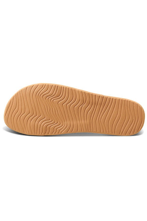The image displays the sole of the REEF Cushion Vista Duo sandal, featuring a light brown color and a wavy, textured tread pattern, known for its cushion bounce comfort.