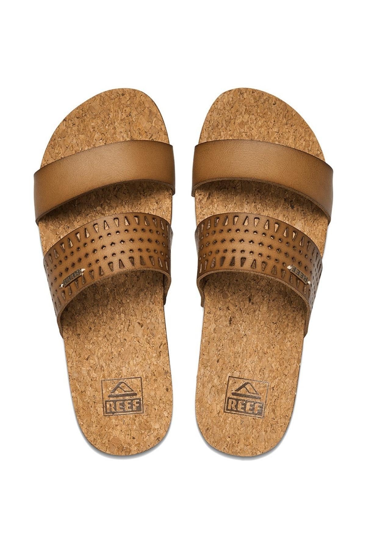 The REEF Cushion Vista Perforated sandals feature two brown leather straps per sandal, cork soles, plain top straps, lower straps with small triangular cutouts, built-in arch support for added comfort, and "REEF" embossed on the soles.