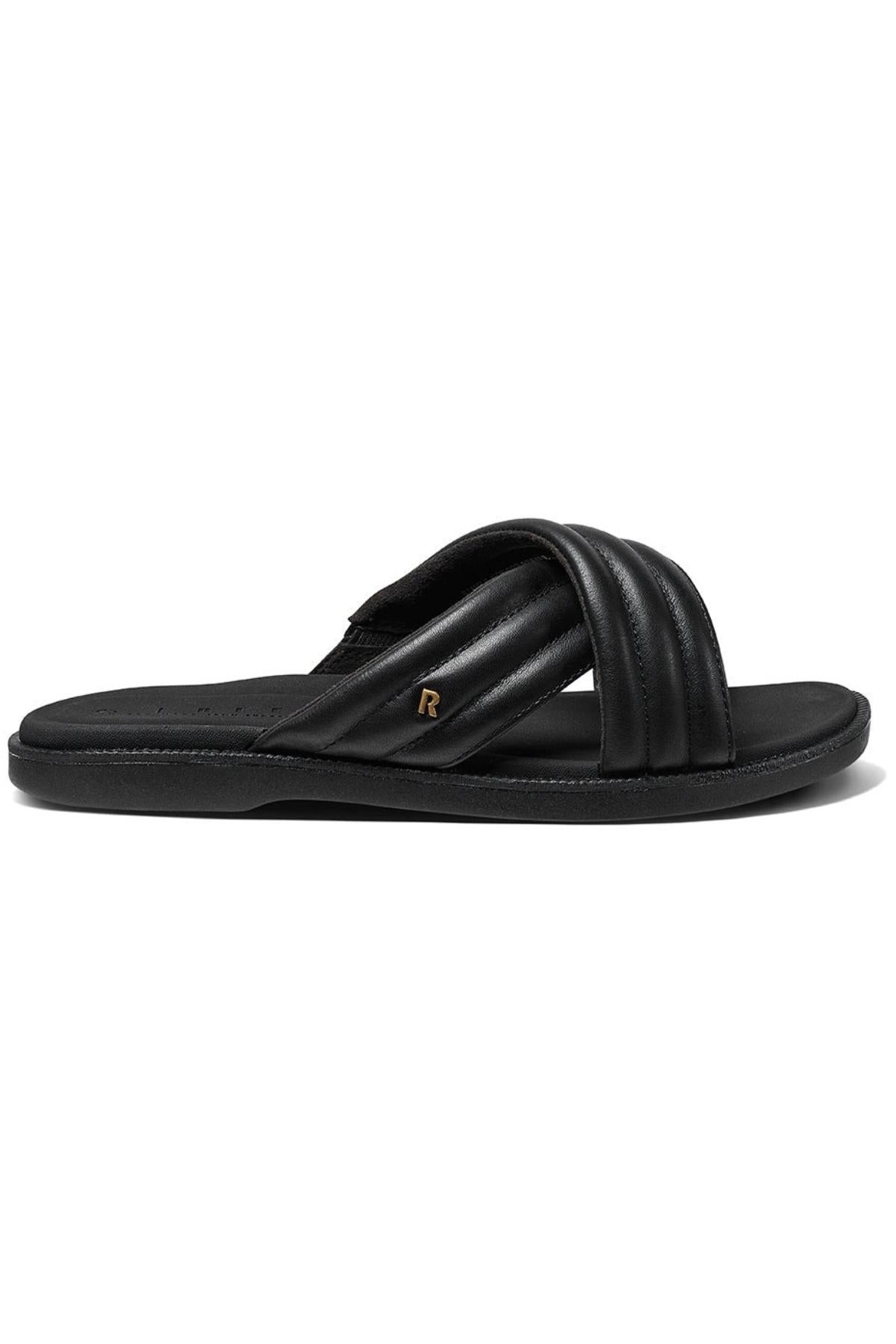 The REEF Lofty Lux X slide sandal in black features two padded crisscross straps, a small gold "R" emblem on the side, and is designed for premium comfort. Shown in a side profile against a white background.
