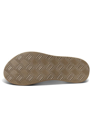 A close-up view of the sole of the REEF Phantom Nias sandal showcases a meticulously patterned design with intricate zigzag lines on durable brown rubber material. Photographed flat against a white background, the image highlights its textured surface and superior traction capabilities.