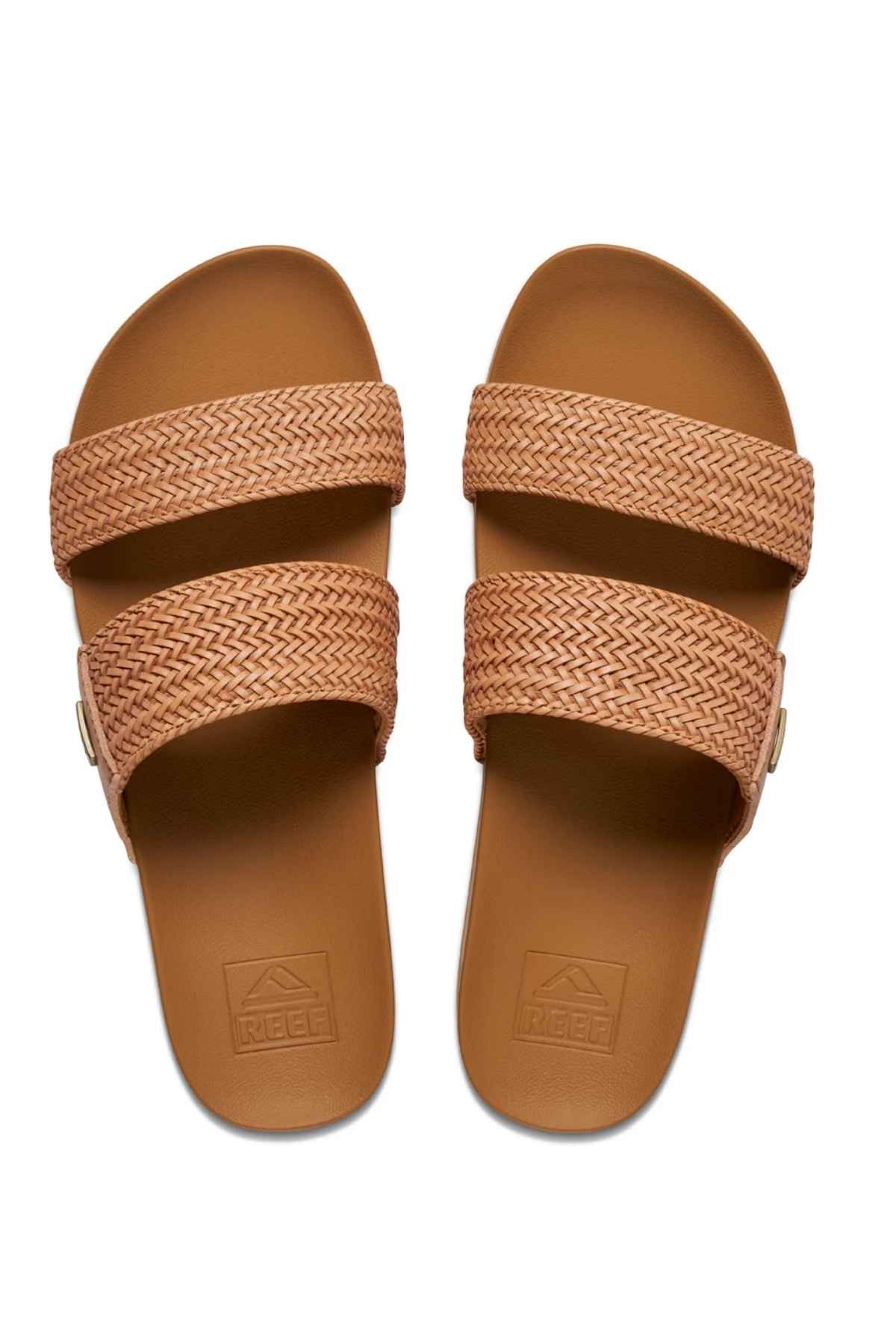 The REEF Vista Braid II eco-friendly brown sandals feature cushioned midsoles, flat soles for comfort, and two textured woven straps. The brand logo is elegantly displayed on the footbed.