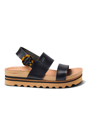 Step up your style with the REEF Vista Hi Buckle—black vegan leather platform sandals featuring two wide straps, a tan cushioned sole, black stripe details, and a chic tortoiseshell ankle buckle.