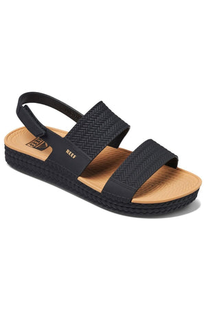 The REEF Water Vista sandal offers arch support with two textured foot straps and an ankle strap. It features a tan insole, textured sole for grip, and prominently displays the "REEF" brand on the side as a classic hallmark.