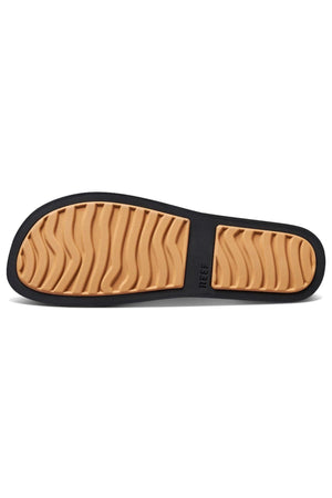 The image displays the sole of a REEF Water Vista sandal with a tan, textured wave-like pattern bordered by black. The word "REEF" is engraved, and the sole includes excellent arch support for all-day comfort.