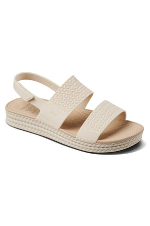 The REEF Water Vista Duo is a beige womenβs sandal with two wide, textured straps, an adjustable Velcro backstrap, and a woven-pattern sole for elevated style and comfort.