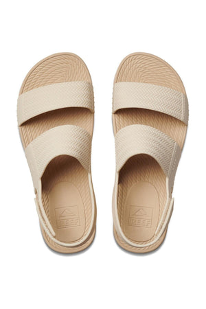 A pair of REEF Water Vista Duo beige slip-on sandals with two wide top straps, textured soles, and a lightweight dual-density EVA footbed, shown from above on a white background.