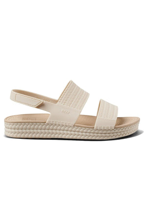 The REEF Water Vista Duo is a beige sandal featuring a textured sole, two wide woven-style straps, an open heel with adjustable Velcro backstraps, and a dual density lightweight EVA footbed for enhanced comfort.