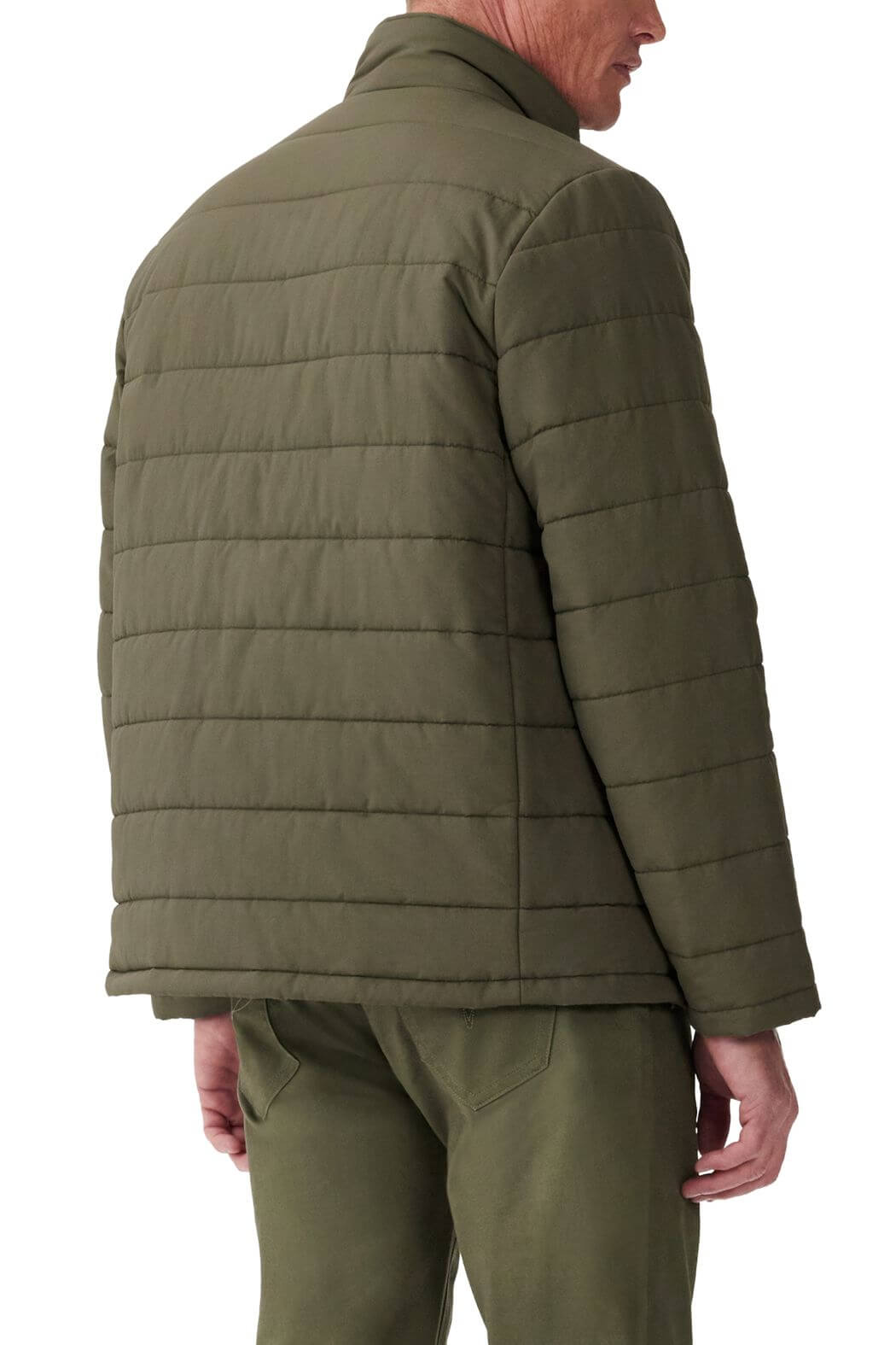 A person stands with their back turned, wearing an olive RM Williams Patterson Creek Jacket paired with matching pants. This quilted puffer jacket features horizontal stitching and a collar, with the image focusing on the upper body and clothing details.