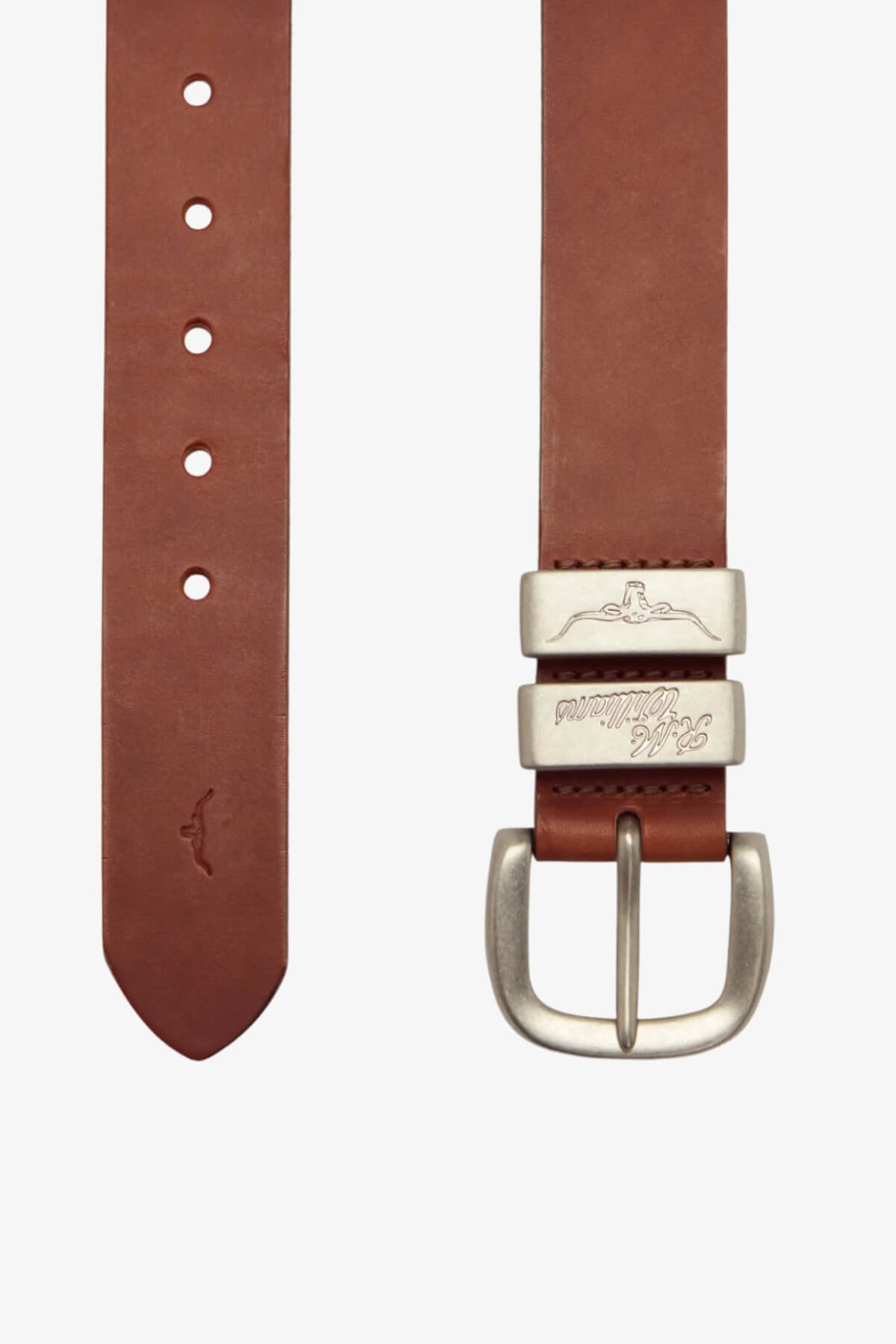 The RM Williams 1 1/2 3 Piece Solid Hide Belt is a brown leather belt featuring a brushed nickel buckle, two decorative loops (one with an engraved whale, the other with script), five visible holes, and an embossed whale near the tip. Made in Australia.