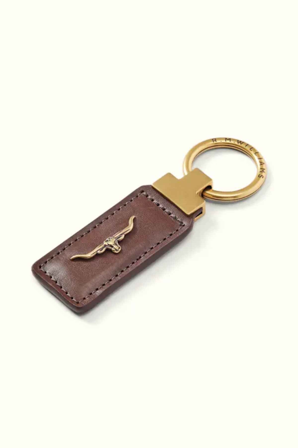 Introducing the RM Williams Angaston Key Fob, a genuine full-grain leather keychain in brown, embellished with an antique brass ring and adorned with a metallic bull emblem. Proudly crafted in Australia.