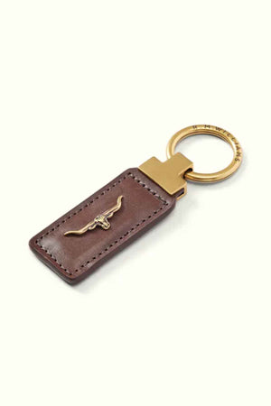 Introducing the RM Williams Angaston Key Fob, a genuine full-grain leather keychain in brown, embellished with an antique brass ring and adorned with a metallic bull emblem. Proudly crafted in Australia.