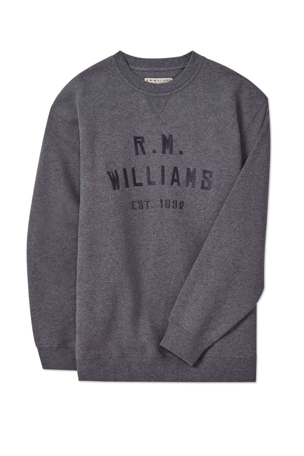 The RM Williams Bale Sweatshirt in heather grey fleece features "R.M. Williams Est. 1932" boldly on the front, capturing classic outback style. The crewneck is displayed flat on a white background for a clean, modern look.
