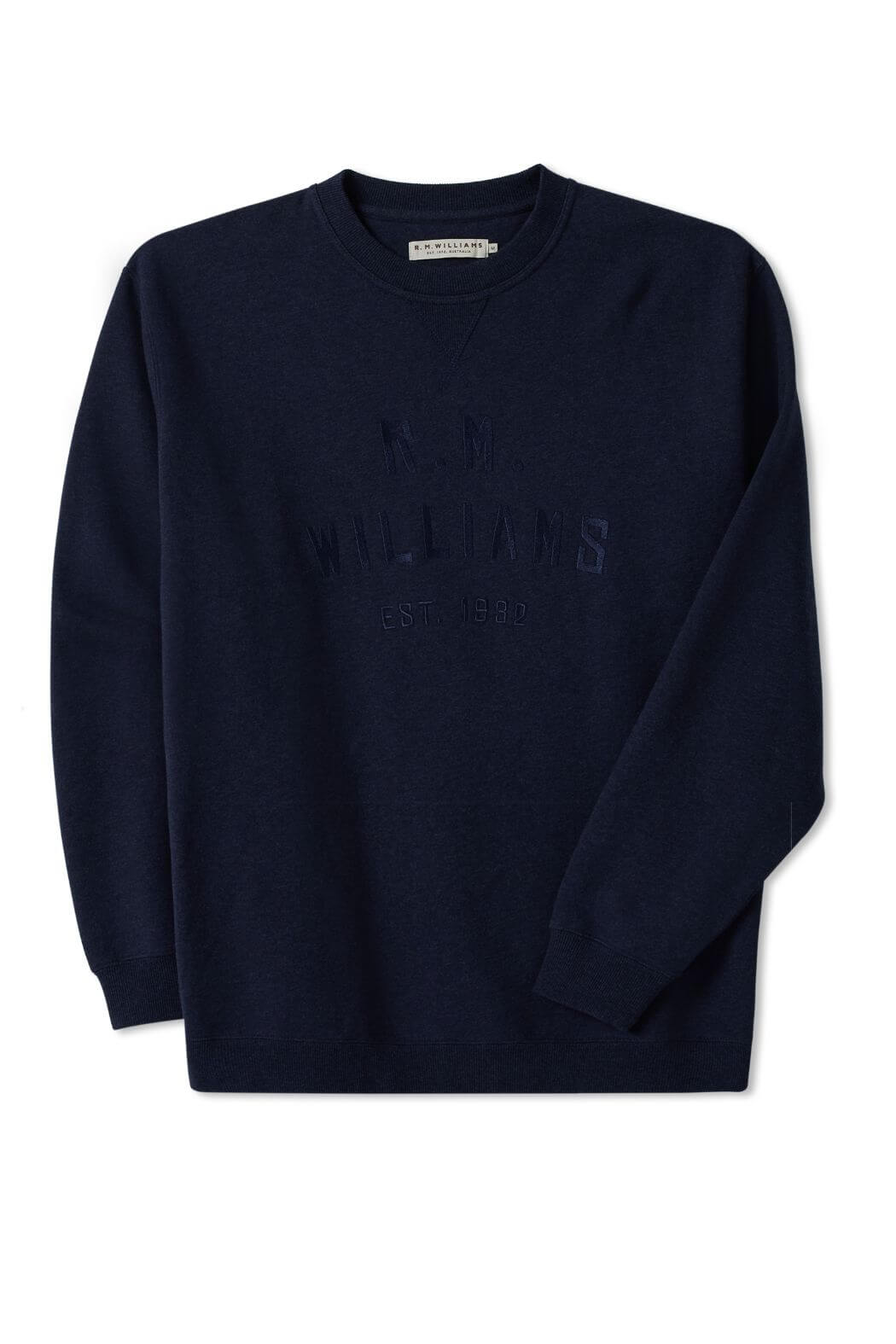 The RM Williams Bale Sweatshirt is a navy blue fleece, featuring "R.M. Williams EST. 1932" embossed on the front in a darker shade. Made from an organic cotton blend, it embodies outback style with a visible brand tag at the neckline and is showcased flat against a white background.