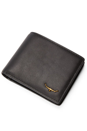 The RM Williams Bi Fold Wallet with Pocket, made from black full-grain leather, features a small gold longhorn emblem in the bottom right corner and is photographed on a white background.