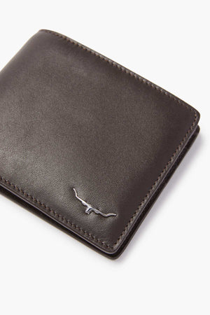 A close-up of the RM Williams City Slim Bi-Fold wallet, crafted from dark brown full grain leather with a silver longhorn logo in the corner. It features multiple card slots, all set against a pristine white background.