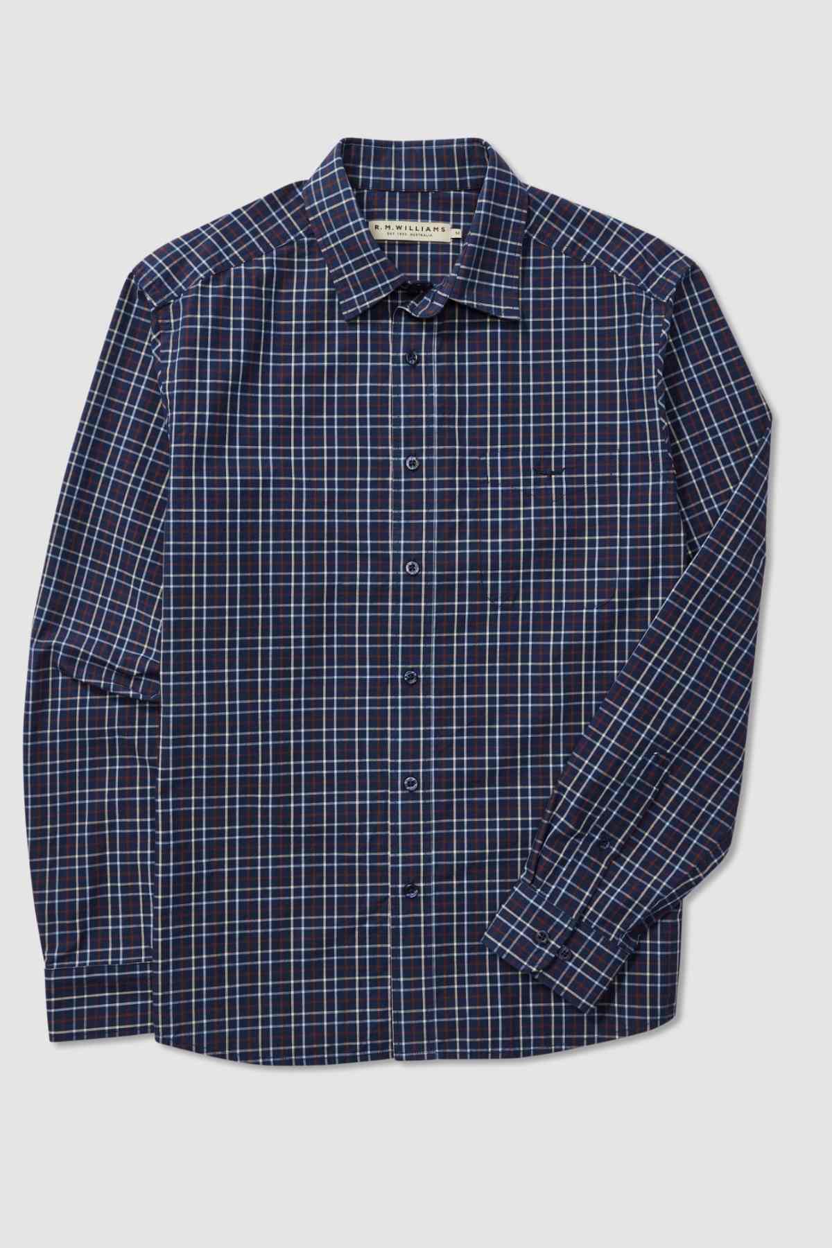 The RM Williams Classic Shirt is a dark blue long-sleeve button-up with a collar and features a sophisticated checkered pattern of thin blue, red, and white lines. This smart casual, regular fit shirt includes a single chest pocket on the left side and is crafted from organic cotton. The shirt is neatly displayed flat against a white background.