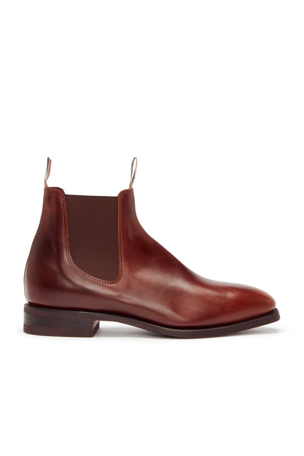 The RM Williams Comfort Craftsman Boot is a single brown yearling leather Chelsea boot with elastic side panels, front and back pull tabs, and a rubber welt sole, shown in side profile on a white background.
