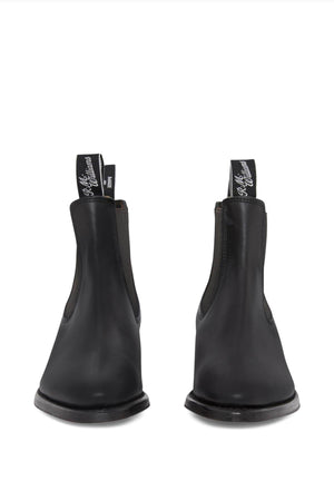 A pair of RM Williams Comfort Lady Yearling Rubber Sole leather Chelsea boots in black, featuring elastic side panels and pull tabs. These stylish boots are displayed from the front on a white background.