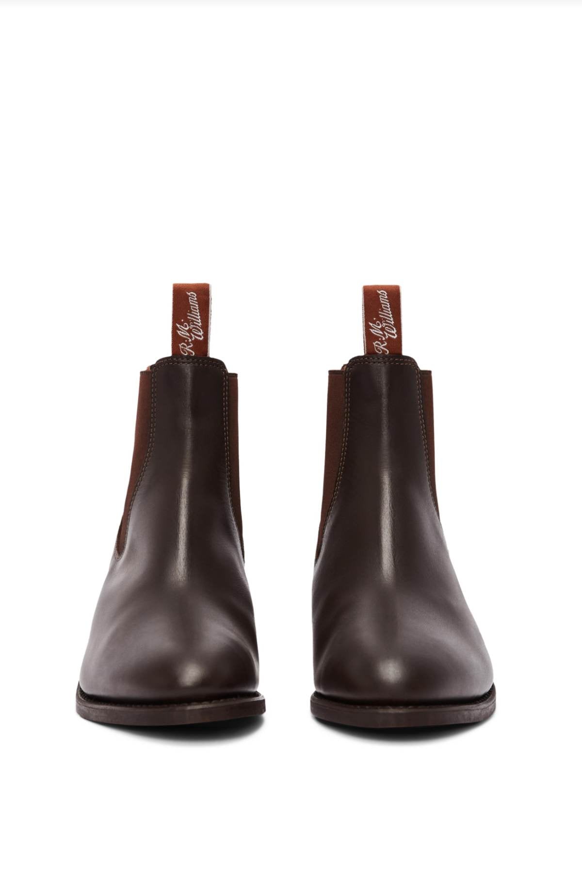 The RM Williams Comfort Lady Yearling Rubber Sole Boot, a pair of dark brown leather Chelsea boots with elastic side panels and pull tabs at the back, featuring a subtle block heel, is placed on a white background.