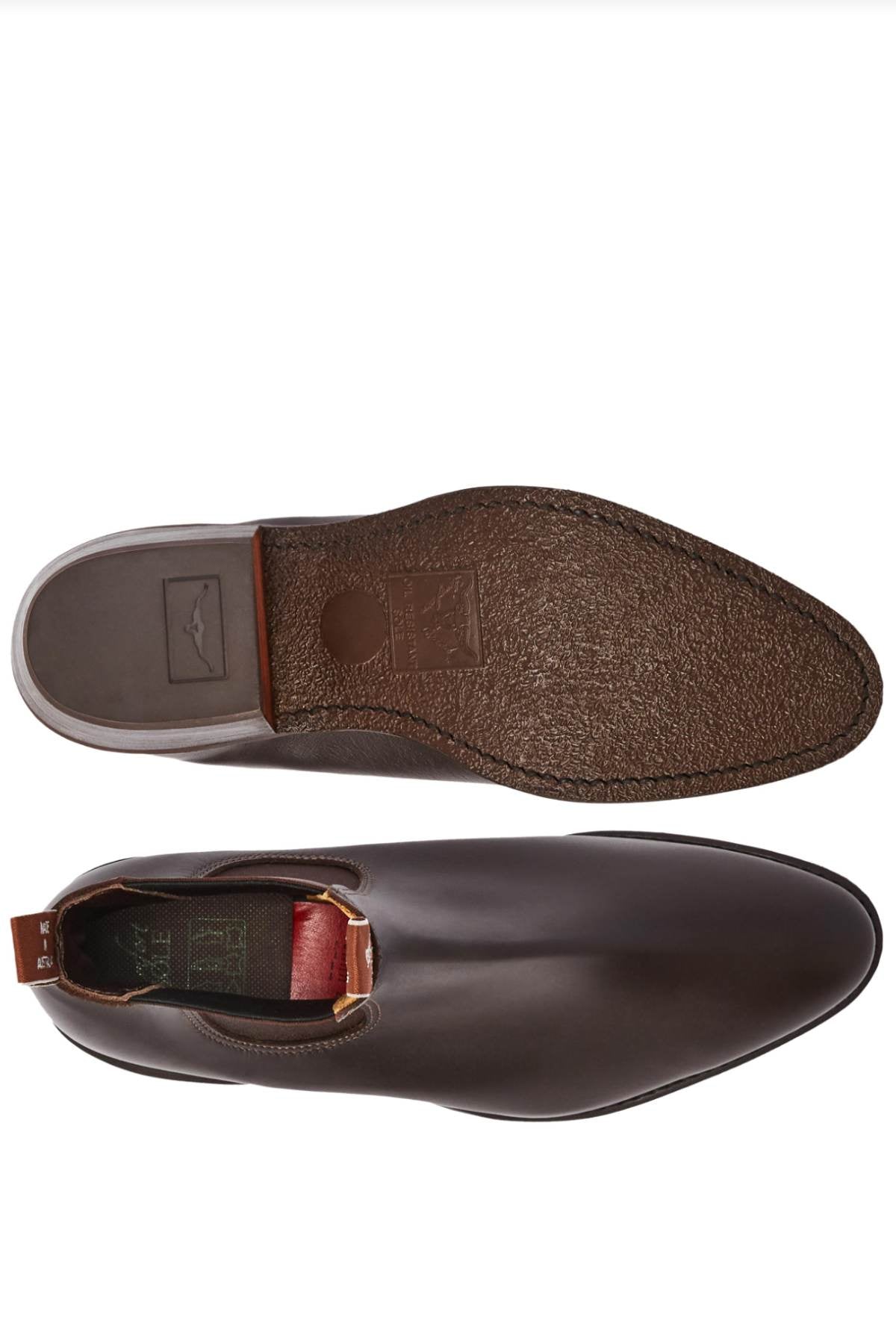 A pair of RM Williams Comfort Lady Yearling Rubber Sole Boots, showcased from the top and sole views. The top view emphasizes a sleek brown leather finish, while the outsole reveals a textured pattern. A red pull tab at the heel brings to mind the classic Yearling boot style.