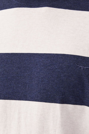 The RM Williams Copley T-Shirt features alternating horizontal stripes in navy and light beige cotton. A small, minimalist longhorn embroidery in navy adorns one of the beige stripes. Its texture appears soft with a slightly heathered finish.