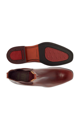 Behold the top and side view of the RM Williams Dynamic Flex Craftsman Boot, crafted from luxurious brown yearling leather with an elegant design. The red and black sole features visible treads, complemented by a subtle heel and elastic side panels for effortless slip-on convenience.